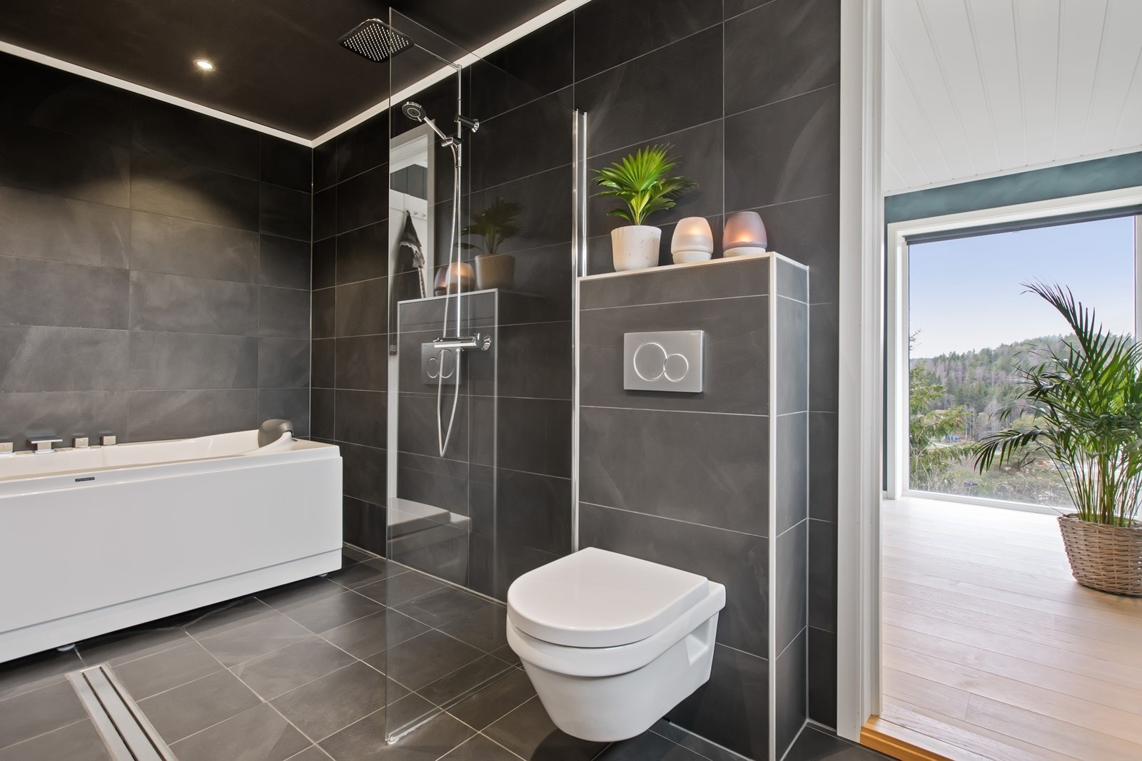 Badet har to regnfallsdusjer, to hånddusjer, LED-downlights og mørke, flislagt overflater. Galleribilde