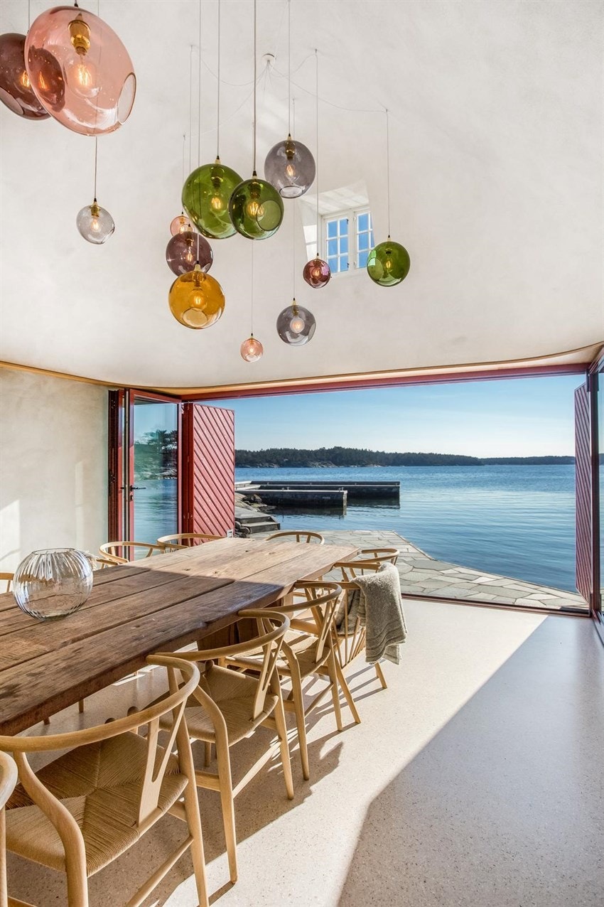 Bilde fra den renoverte sjøbua hvor man kan åpne frontdører og sitte inne og nyte utsikten Galleribilde