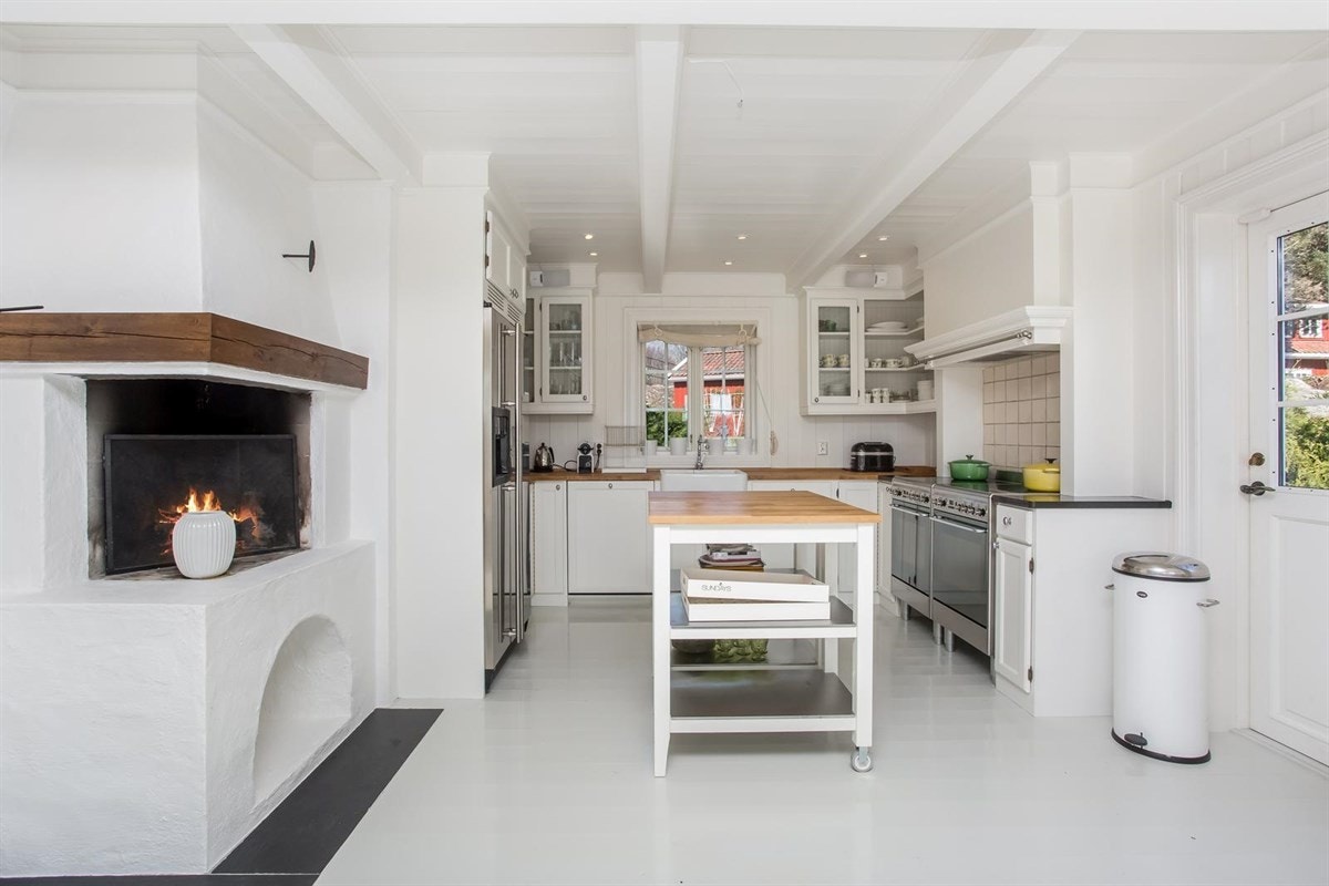 Pent kjøkken med peis og med utgang direkte til en romslig platting og hage Galleribilde