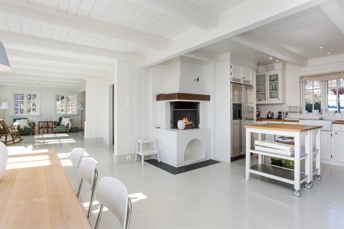 Fra del av kjøkkenet med koselig peisløsning Galleribilde