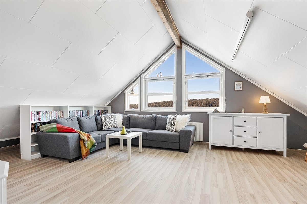 Loftstuen har skråtak, takvindu og høye gavlvinduer som gir godt med lys til rommet. Galleribilde