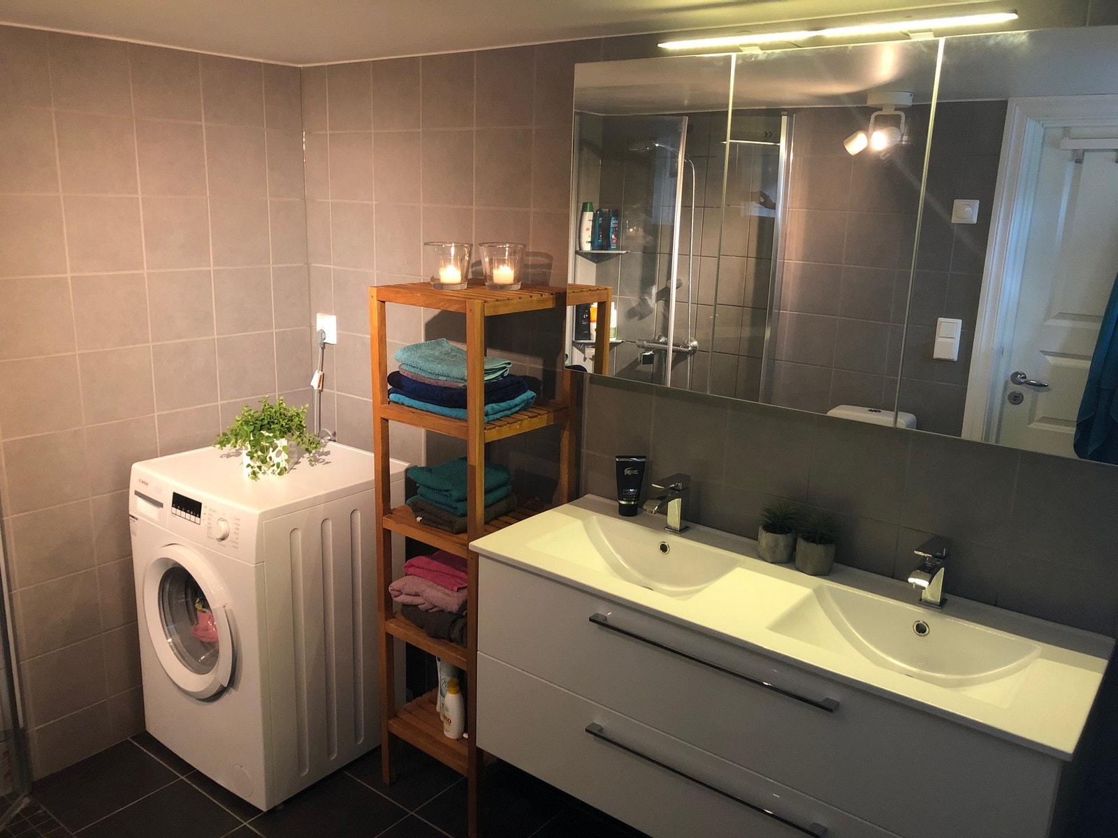 Moderne bad med fliser, gulvvarme og innredning med dobbel vask. Galleribilde