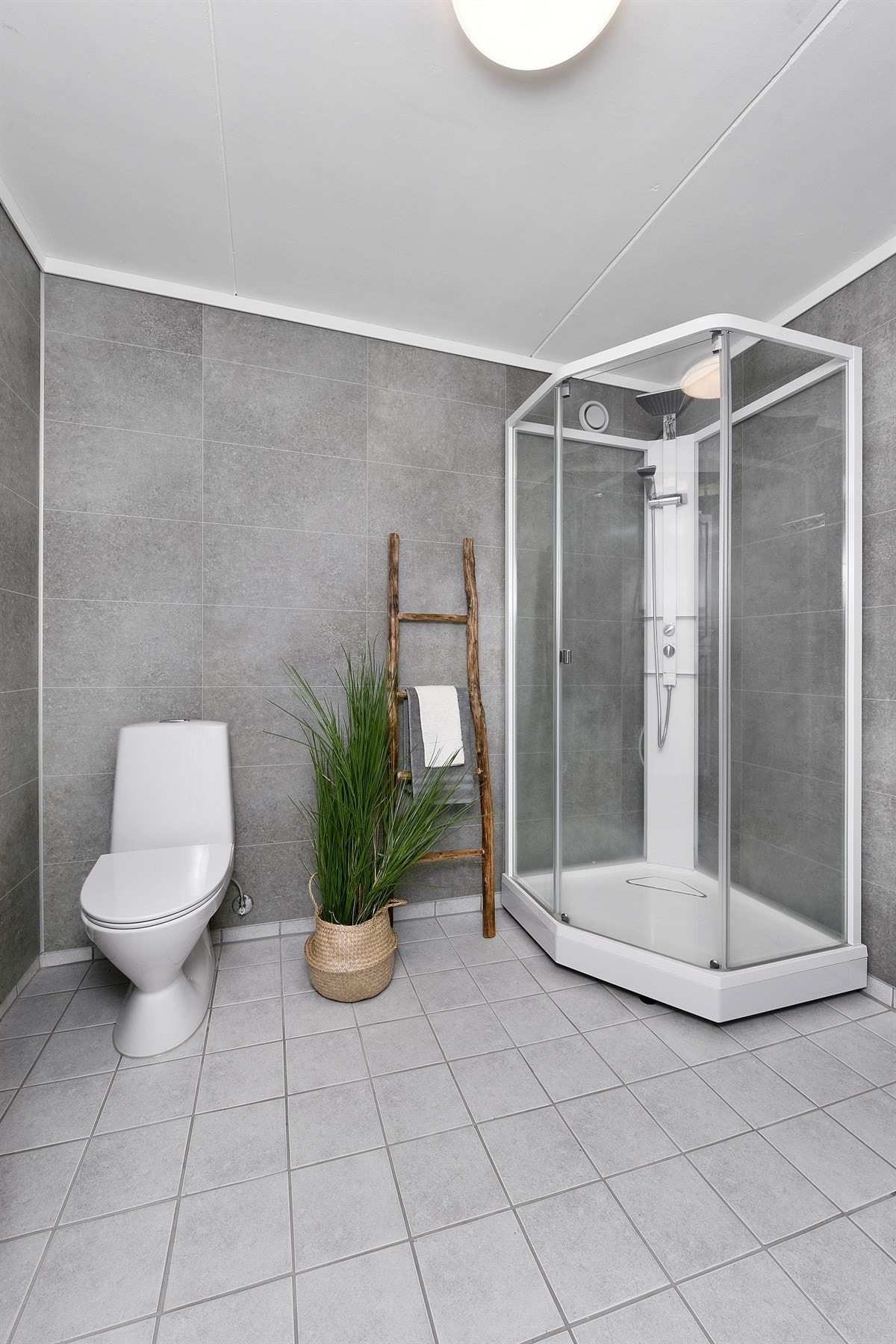 Badet ble pusset opp i 2017 og er tidsriktig og stilig. På veggene er det våtromsplater i grått, og gulvet har fliser i en lysere gråtone samt varmekabler. Galleribilde