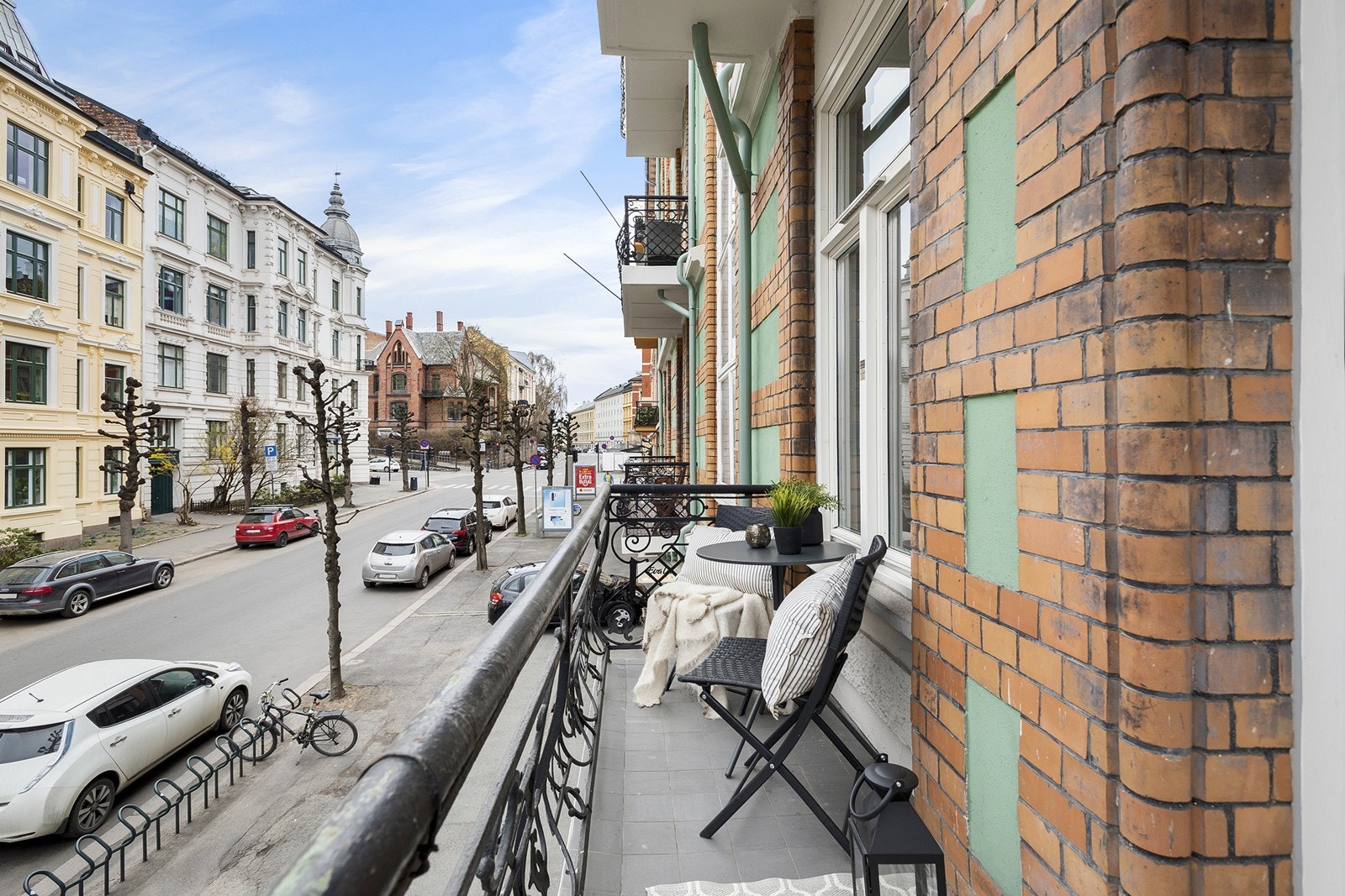 Balkong med morgensol og plass til sittegruppe og bord ut mot hyggelig gate Galleribilde