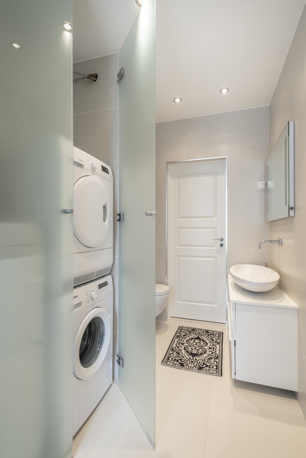 Nisje med glassdører i herdet glass med opplegg for vaskemaskin/tørketrommel og v. bereder. Galleribilde