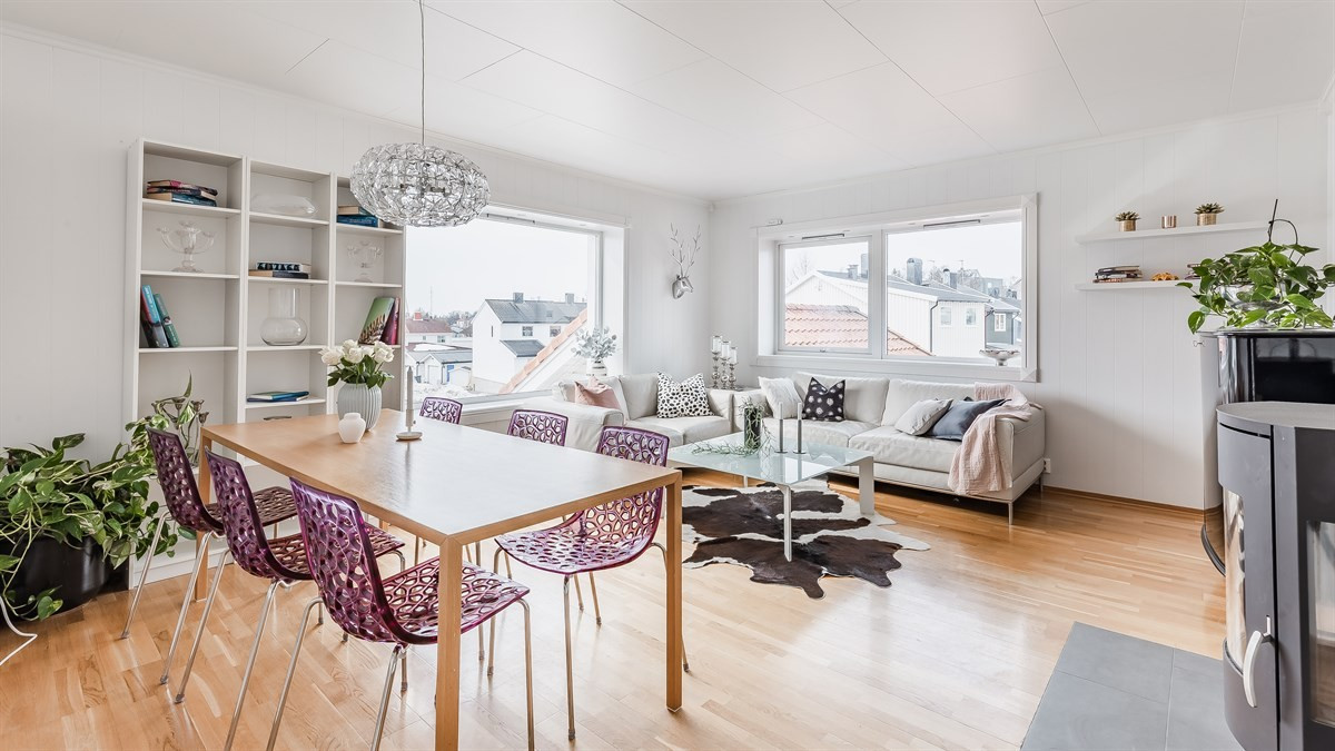 Romslig stue med god plass til salong og spisebord og vedfyring.