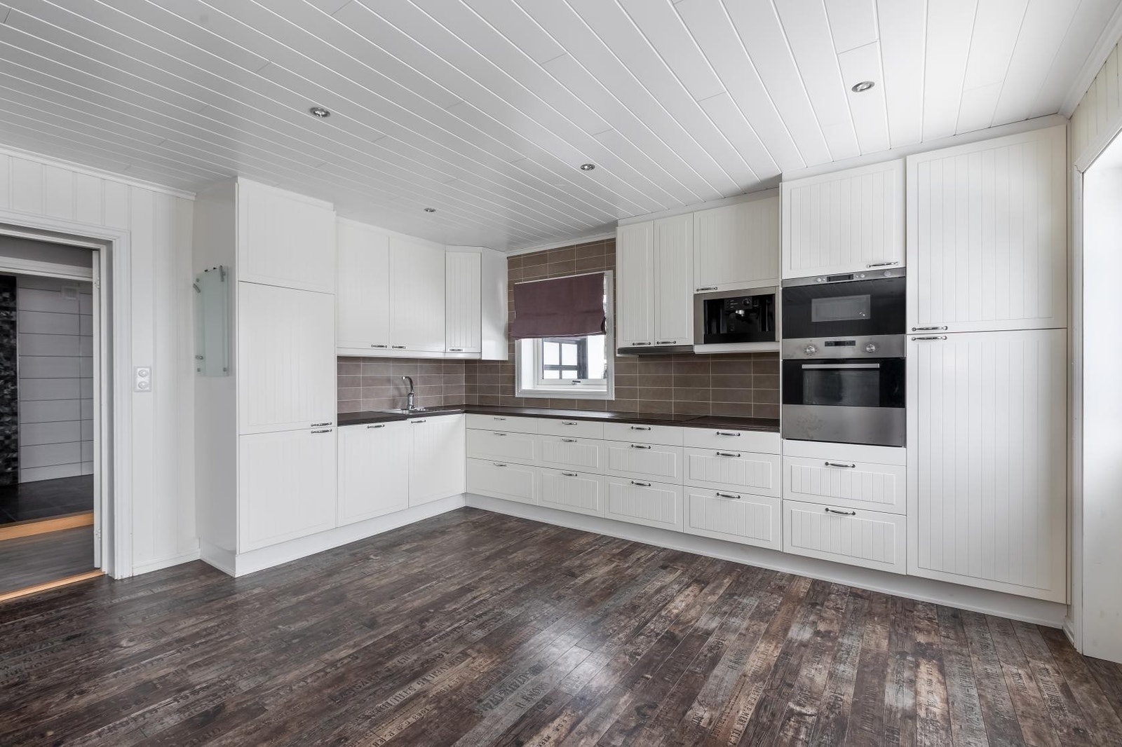 Et tradisjonelt preg med hvite profilfronter og mørkebrun benkeplate. Galleribilde