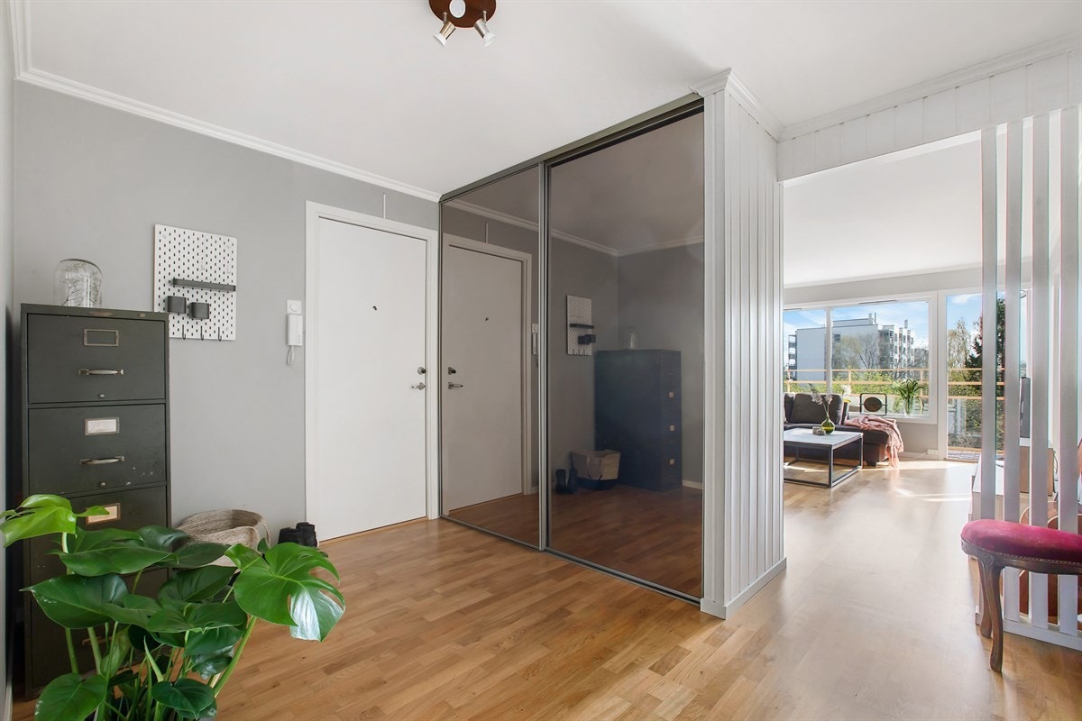 Lys og innbydende entré med gode oppbevaringsmuligheter i garderobeskap med skyvedørsfronter. Galleribilde