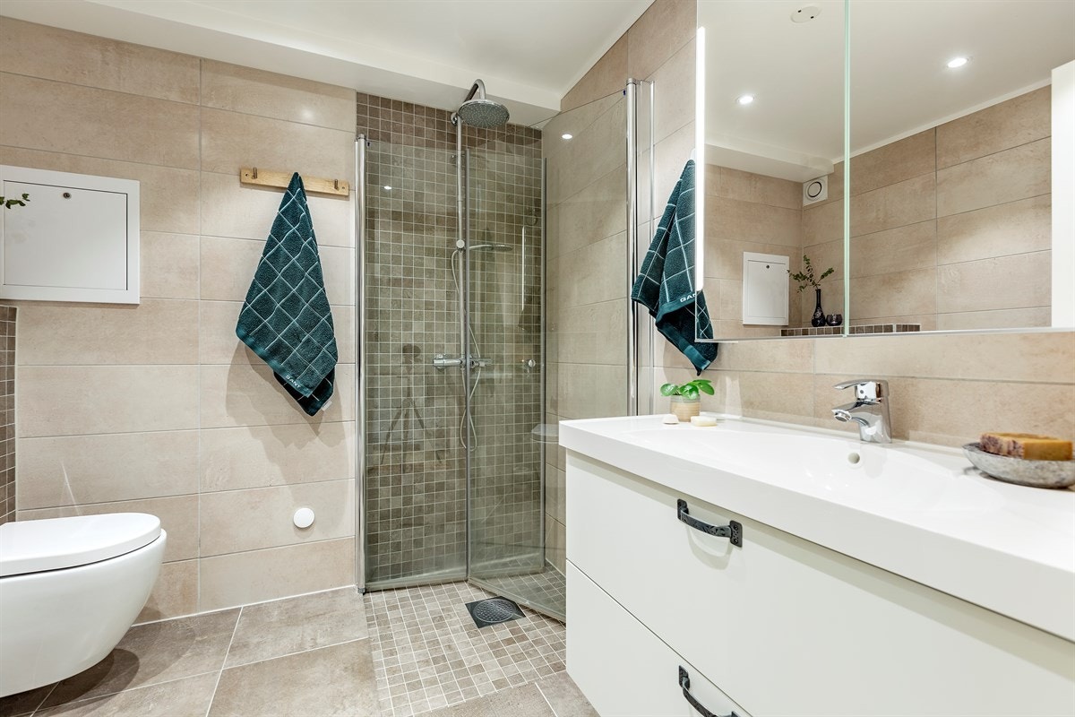 Lekkert bad med gulvvame og downlights. Dusjhjørne, vegghengt WC, servant-/skap, speilskap med lys. Galleribilde