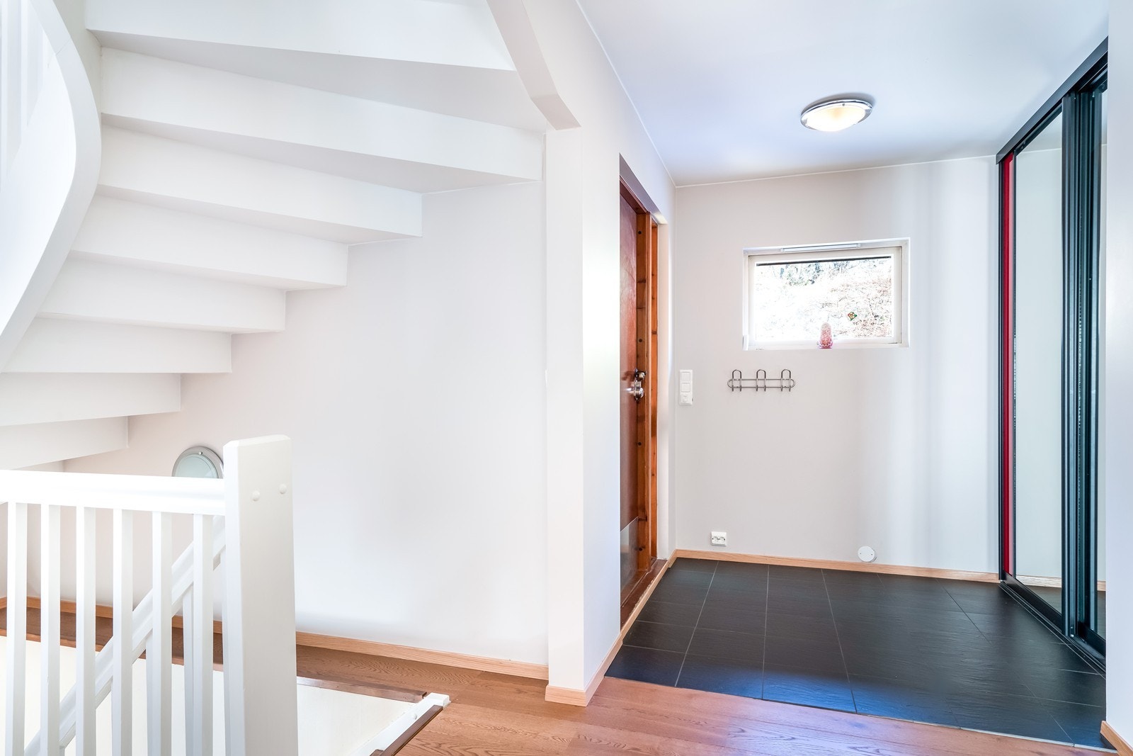Romslig gang med fliser og enstavsparkett av nyere dato. Skyvedørsgarderobe med speil. Galleribilde