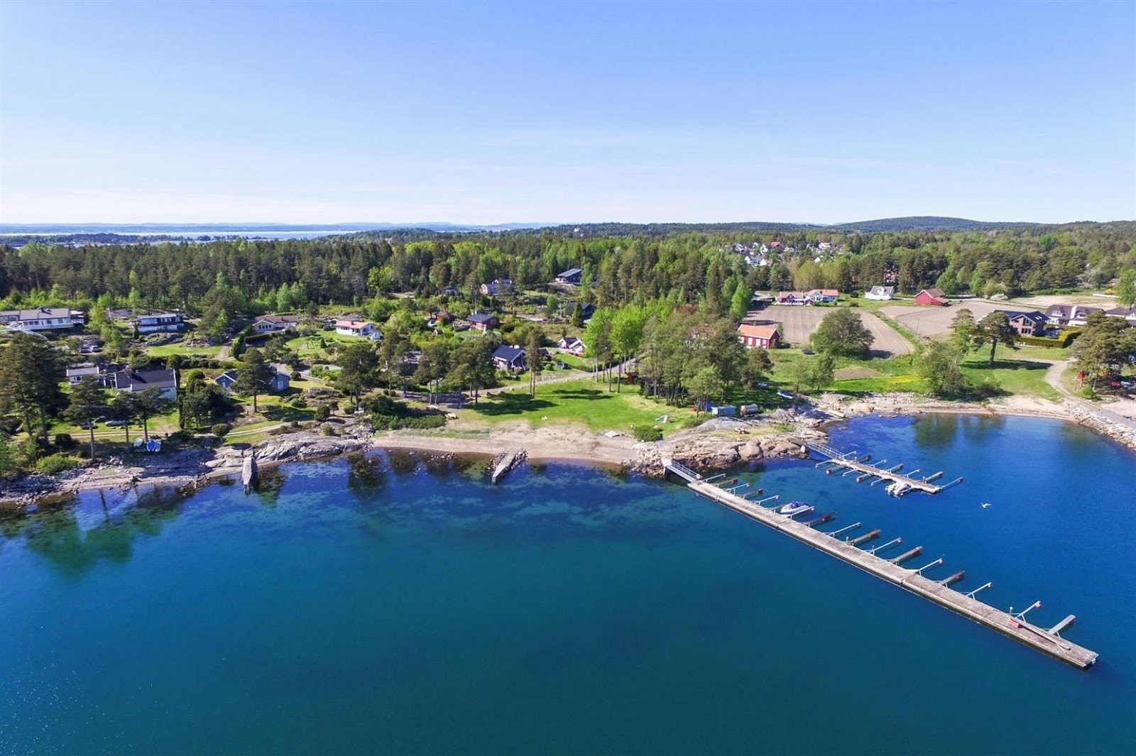 Like ved hytta er fellesområde med strand, fritidsareal og brygge Galleribilde