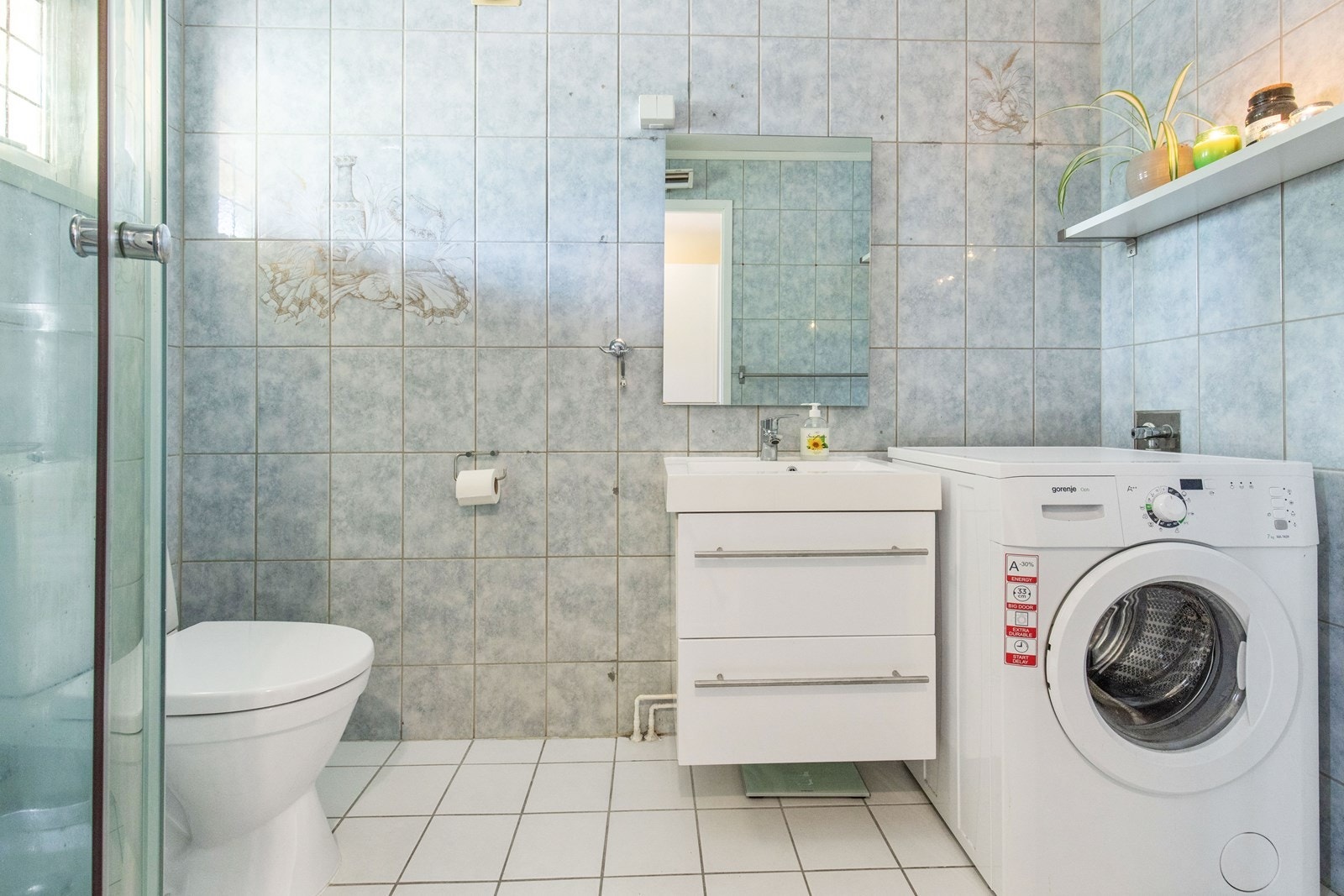 Pent baderom med fliser på gulv og vegger. Galleribilde