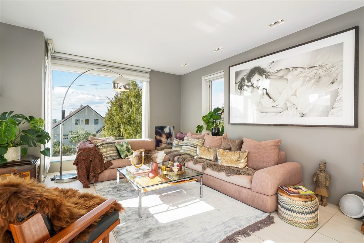 Stuen har store vinduer som gir flott lys inn i boligen. Galleribilde