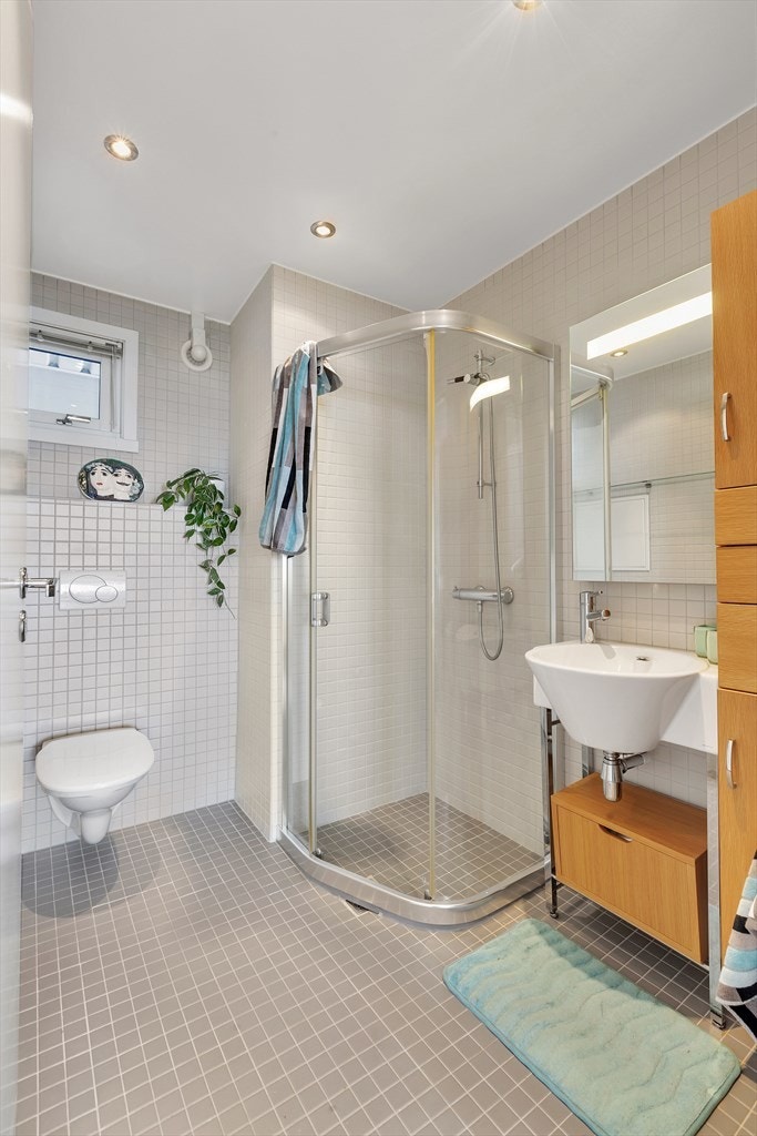 Badrom i plan 2. Dusjvegger, vegghengt toalett og moderne innredninger. Vindu på badet. Galleribilde