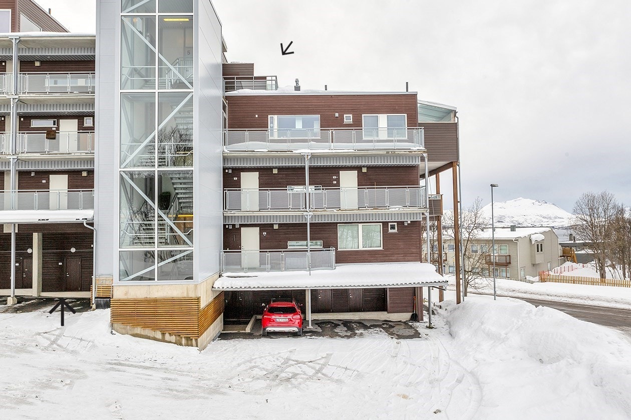 Fasade og carport. Pilene viser carport plass og utstikk av balkongen til leiligheten. Galleribilde
