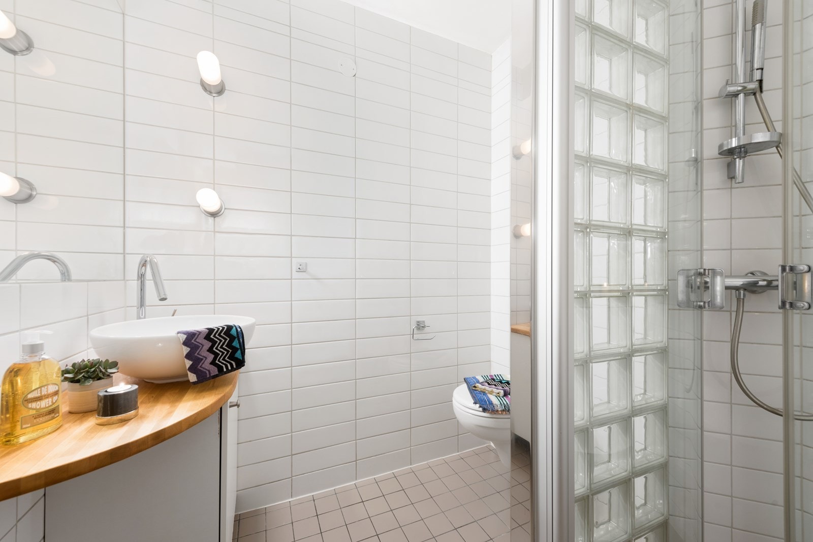 Pent flislagt bad med dusjplass og vegghengt toalett Galleribilde