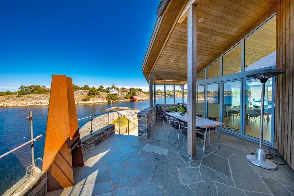 Den vestvendte terrassen har god plass til spisegruppe m.m. Trapp ned til badeplass. Galleribilde