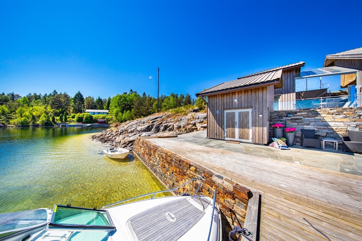 Bryggeområdet med stranden som strekker seg videre rundt på enden av holmen Galleribilde