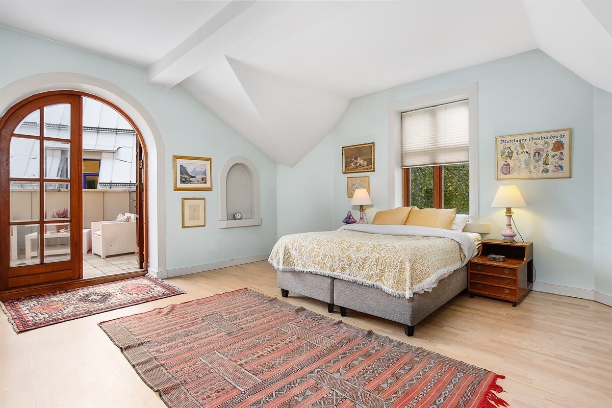 Hovedsoverommet har suiteløsning med adkomst til eget bad og utgang til stor terrasse via dobbelfløyet, buet terrassedør. Galleribilde