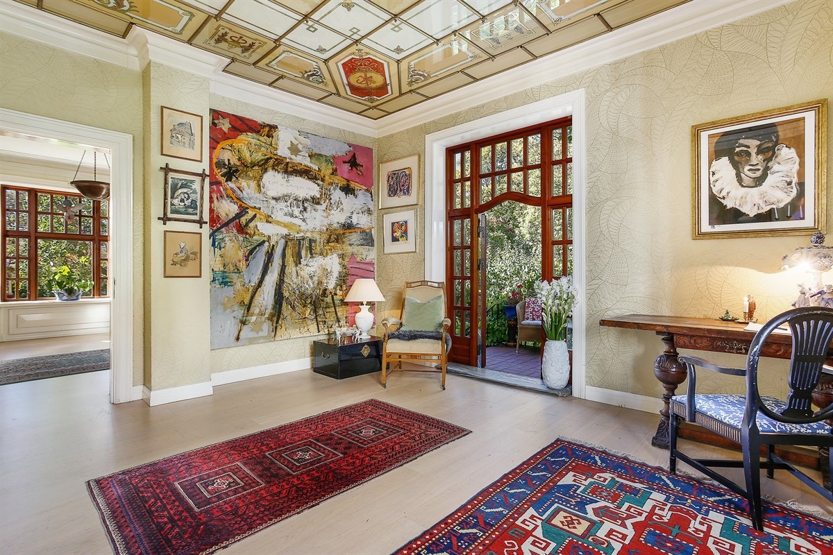 Fra hjørnestuen er det dør til den tredje stuen. Denne har en særegen stil med utsmykket tak og dobbelfløyet vitrinedør til frodig terrasse. Galleribilde