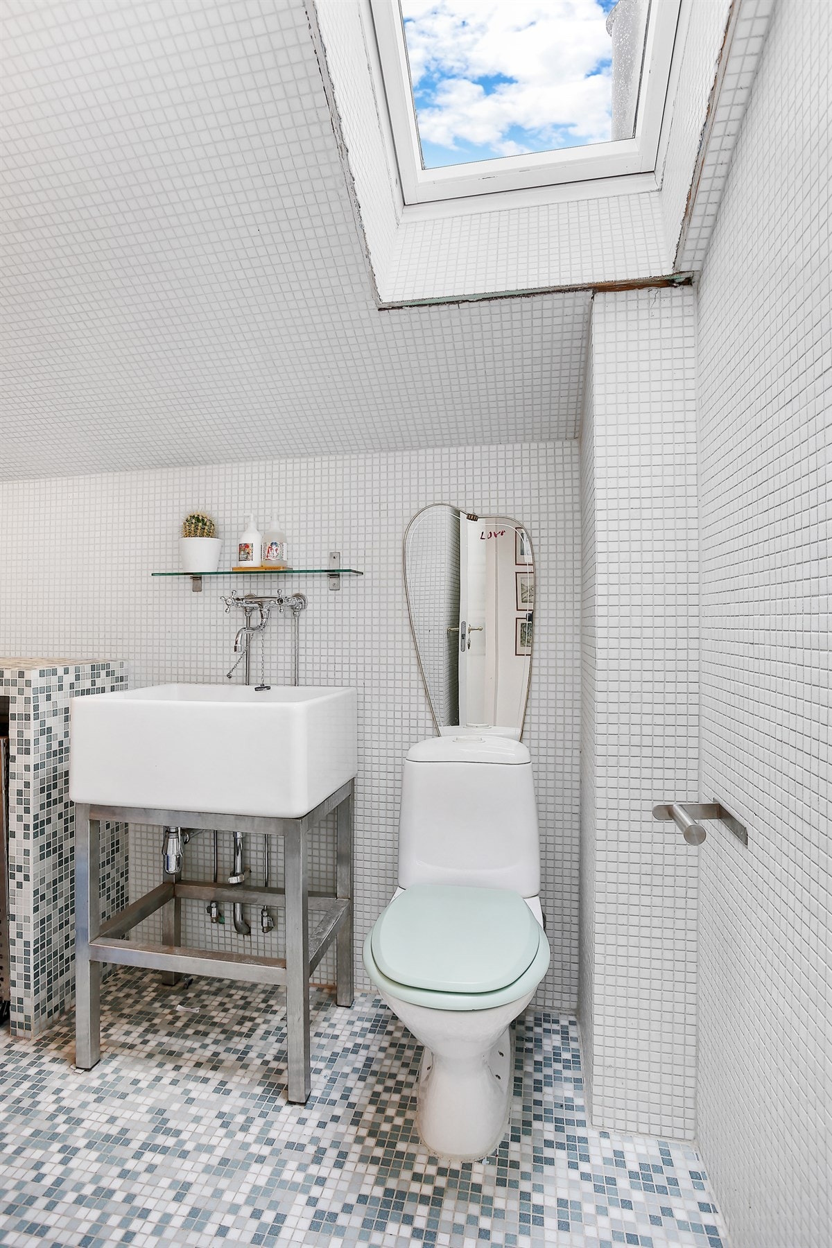 Videre er det gulvstående toalett, utslagsvask, vegghyller og veggmontert tørkestativ. Galleribilde