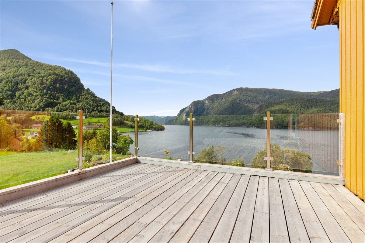 Pen terrasse med glassrekkverk over garasjen. Galleribilde