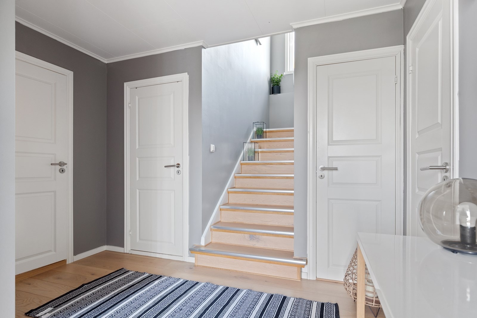 Gangen kobler sammen flere av boligens rom. Inngang til bod med varmtvannsberedere, bod under trapp, liten vaskerom, bad og soverom Galleribilde