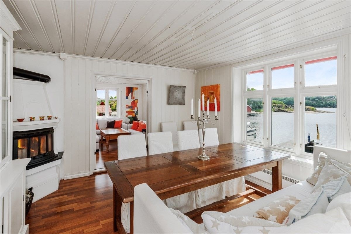 Koselig spisestue med peis og store vinduer som bringer mye lys inn i rommet. Galleribilde