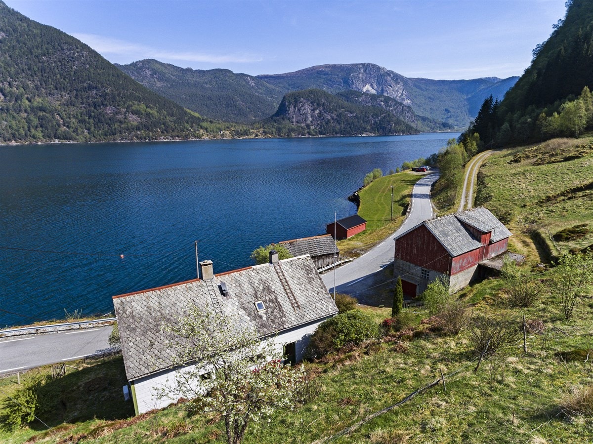 Eit steinkast unna husværet har bruket strandlinje med naust Galleribilde