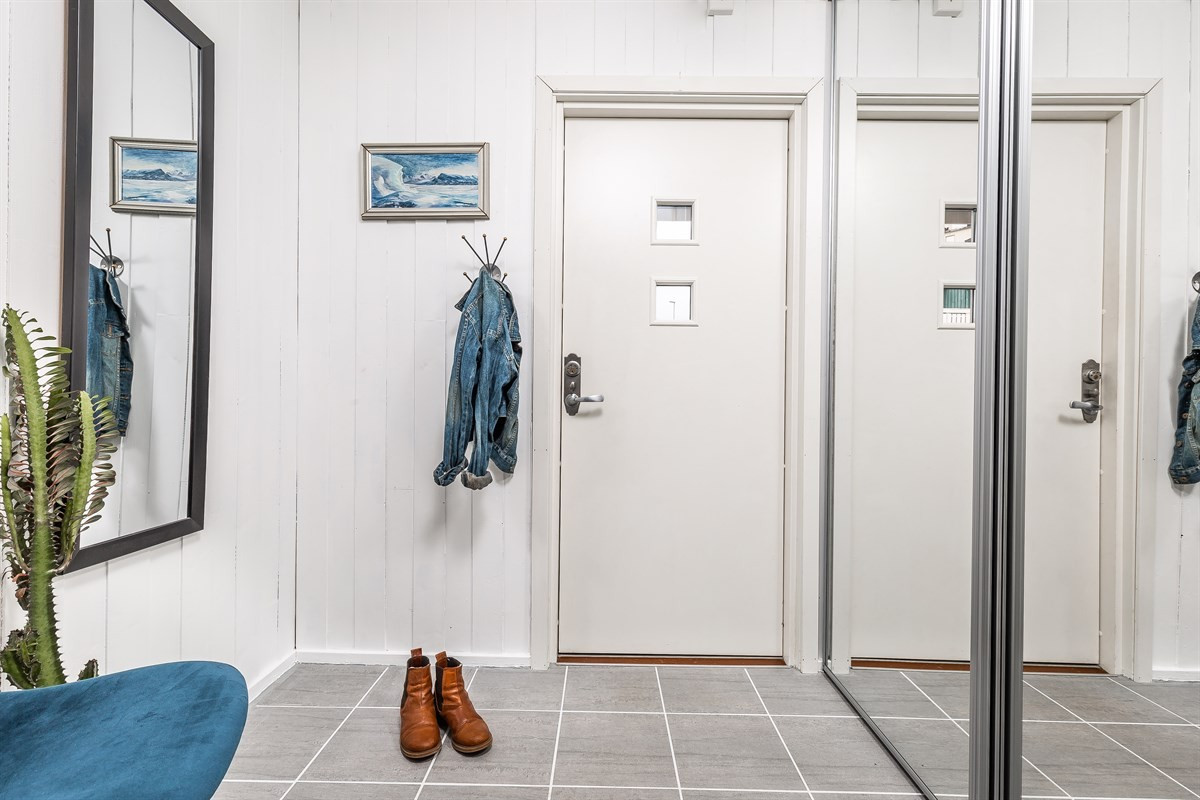Her er det god plass i skyvedørsgarderobe og praktiske fliser på gulv