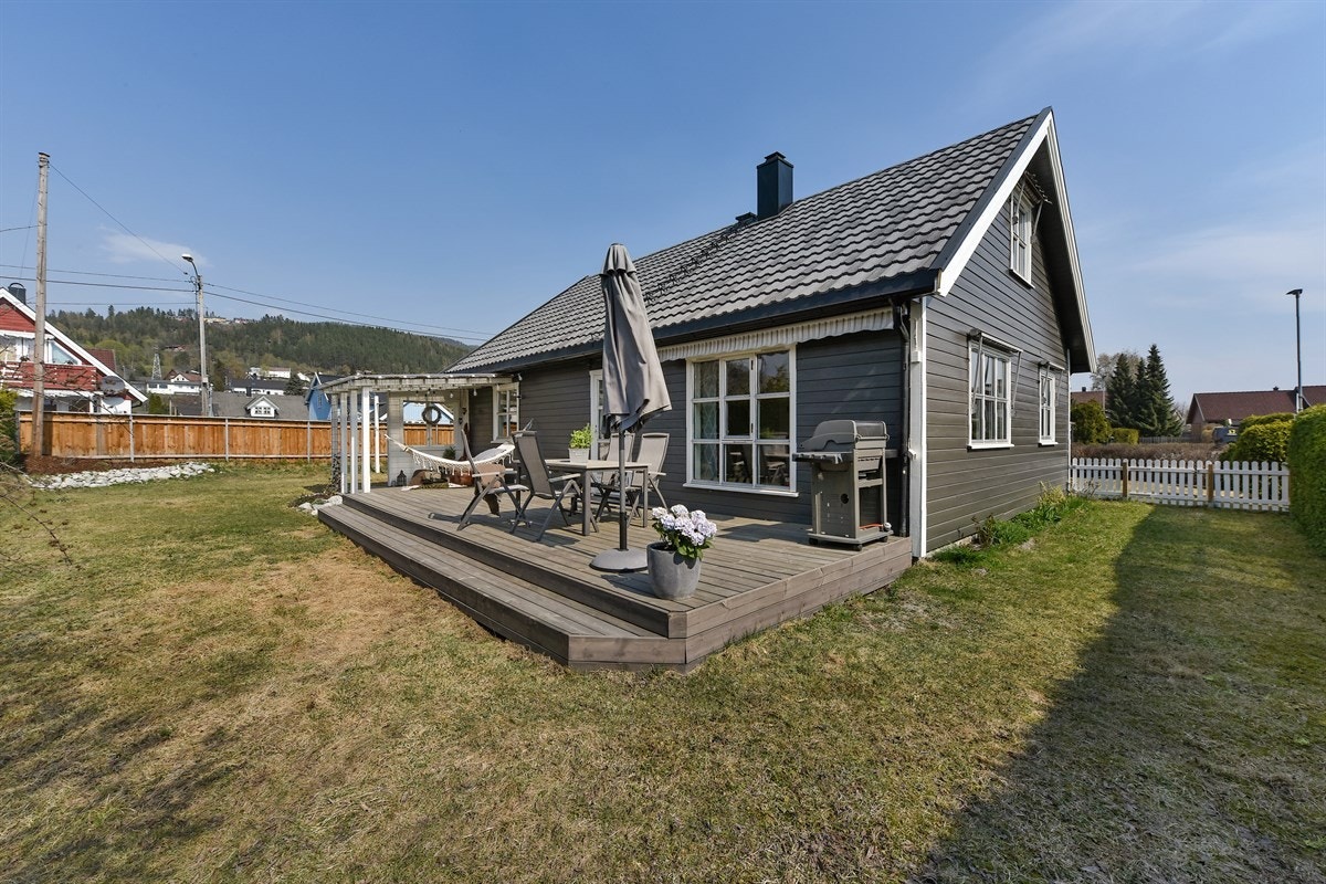 Boligen har hage med plen og beplantning, og en stor, solrik terrasse med en koselig pergola. Galleribilde