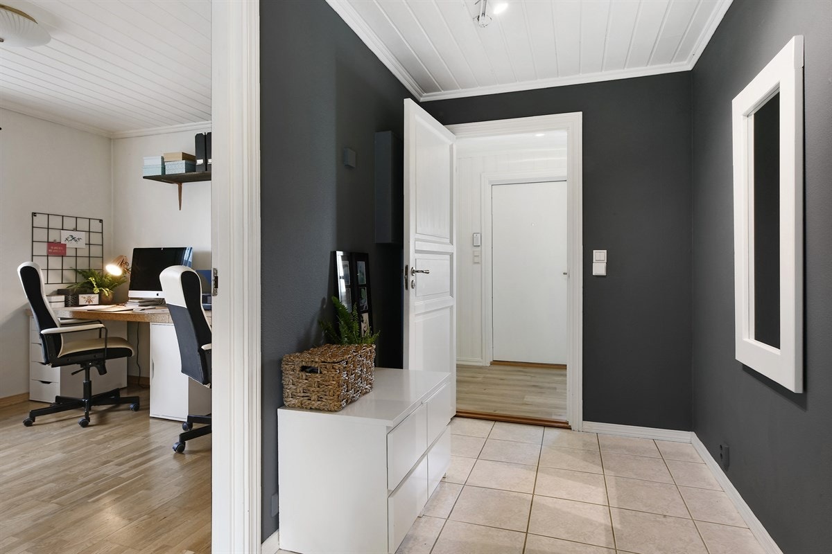 Det er lys laminat på gulvet og åpen garderobeløsning med knagger for yttertøy. Galleribilde