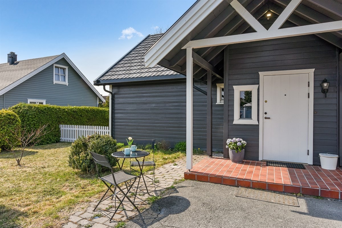 Boligen har et koselig, overbygd inngangsparti og et vindfang med hvitmalt panel på vegger og i himling. Galleribilde