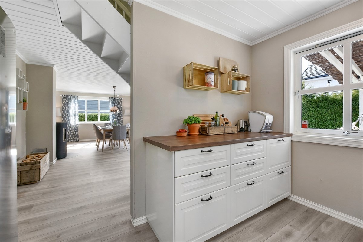 Kjøkkenet har svært god skap- og benkeplass og et stort vindu som gir godt arbeidslys. Veggene er malt i en beige farge, og på gulvet er det laminat. Galleribilde