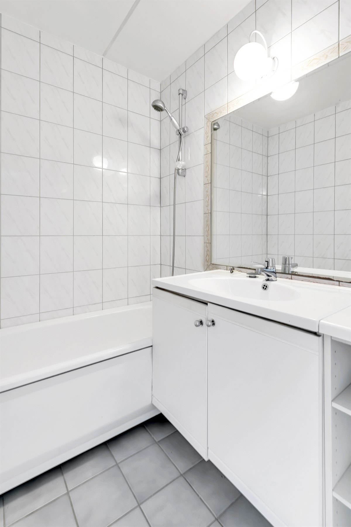 Videre består innnredningen av servantskap og toalettskap med glatte, folierte fronter, heldekkende servant samt speil og lysarmatur på vegg over servant. Galleribilde