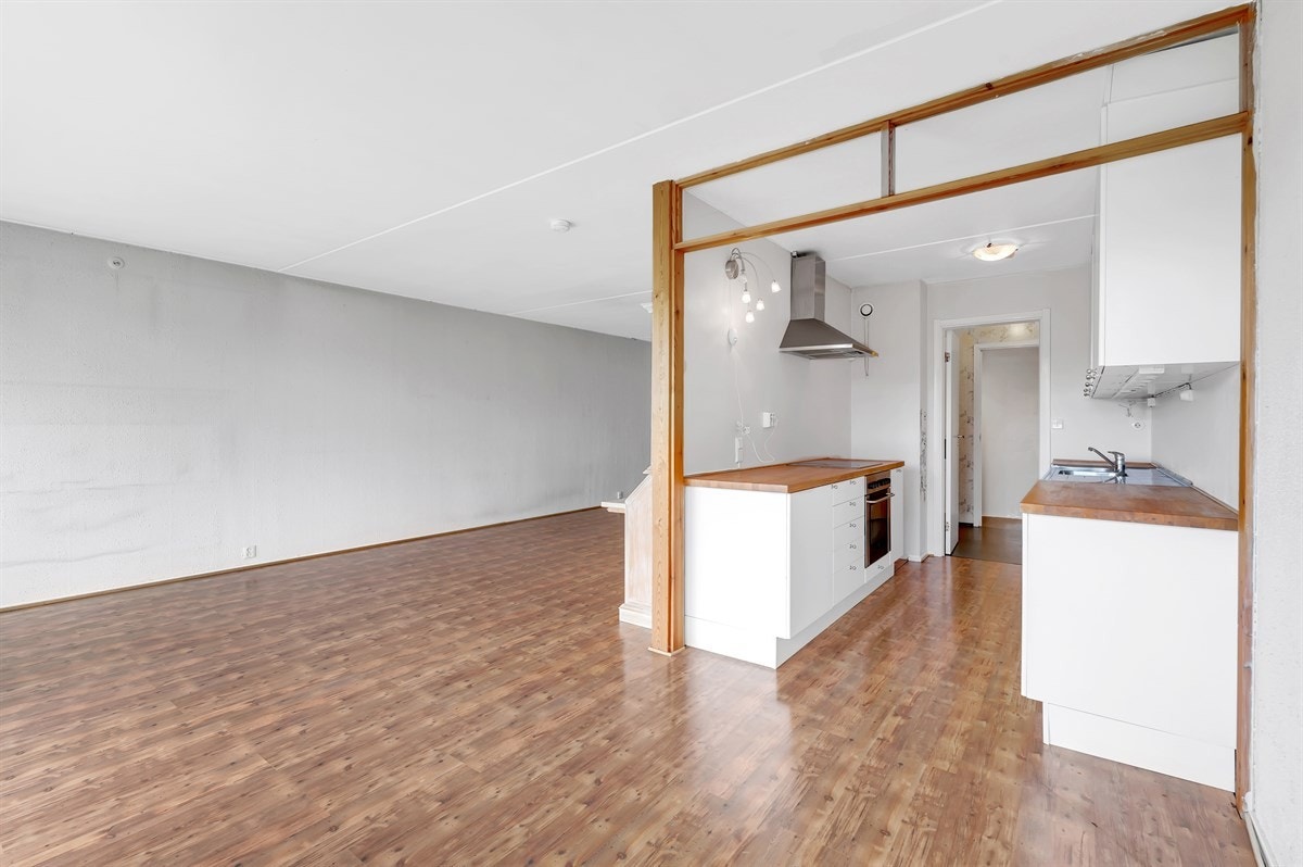 Rommet har en delvis åpen løsning mot kjøkkenet som gjør at tilberedningen av måltidene blir sosial. Galleribilde