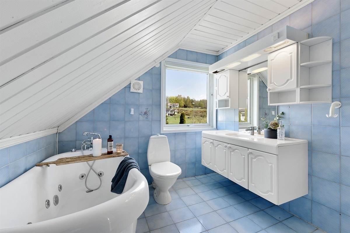 Rommet er utstyrt med heldekkende servant, hvitt servantskap, to veggskap, speilbelysning og toalett. Galleribilde