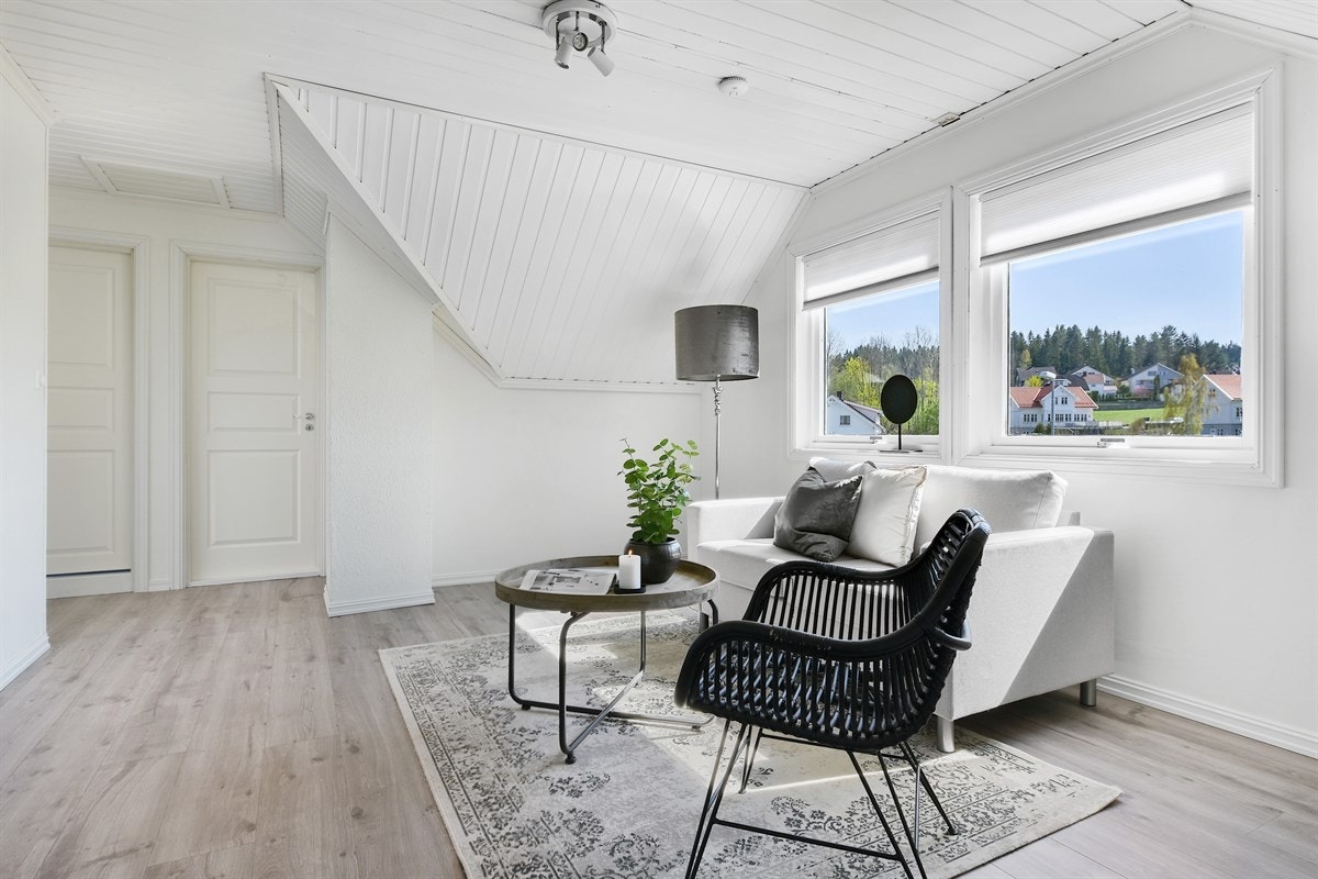 For øvrig har rommet to vinduer med utsikt til skogkledd ås, parkettlaminat på gulv og hvitmalte vegger. Galleribilde