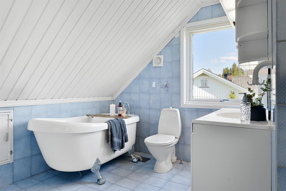 Det trivelige badet ligger i andre etasje, og er innredet med blå fliser på gulv og vegg. Galleribilde