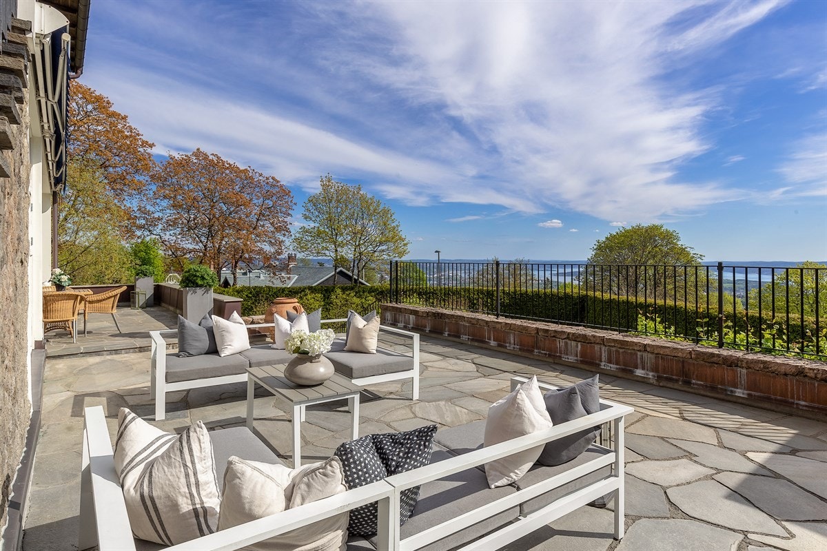 Støpt trapp med skifer i trinn opp til stor terrasse i hele fronten av boligen. Galleribilde