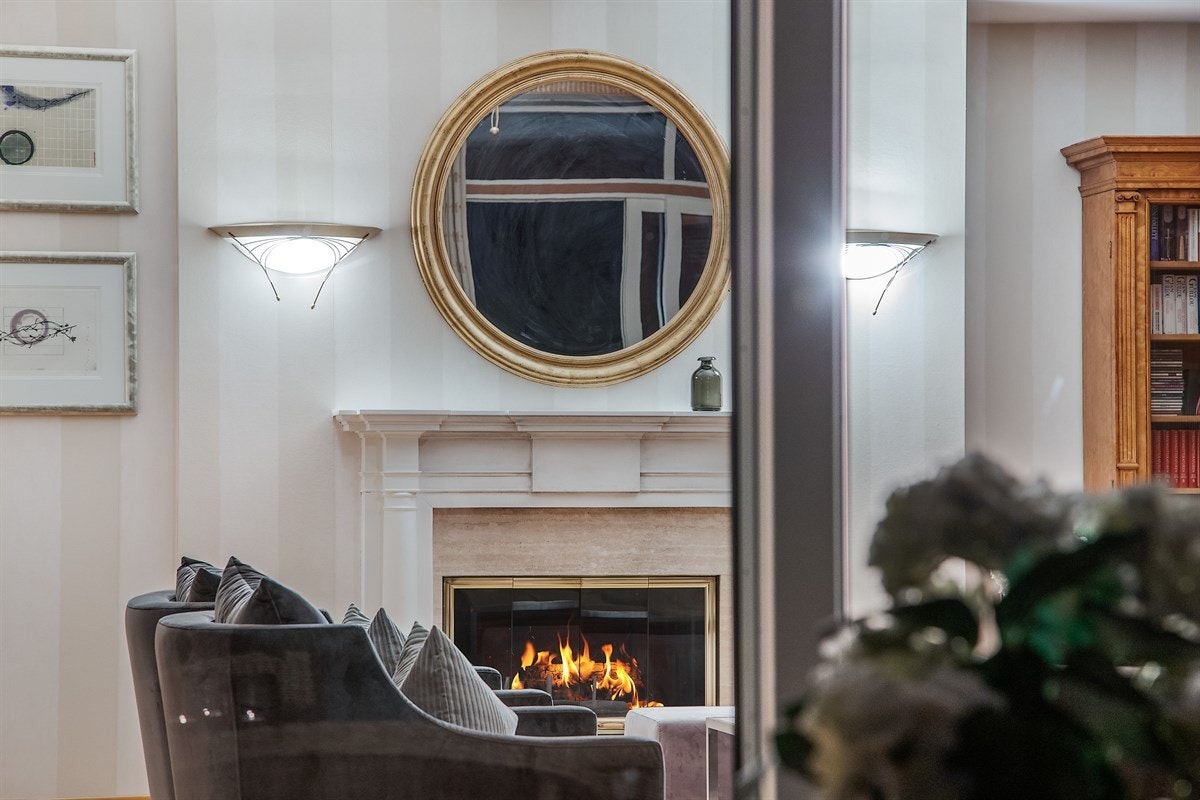 Den store peisen fremstår som et møbel i stuen. Galleribilde