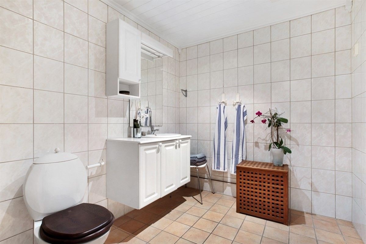 Fint og romslig bad med kombinert vaske/tørkemaskin Galleribilde