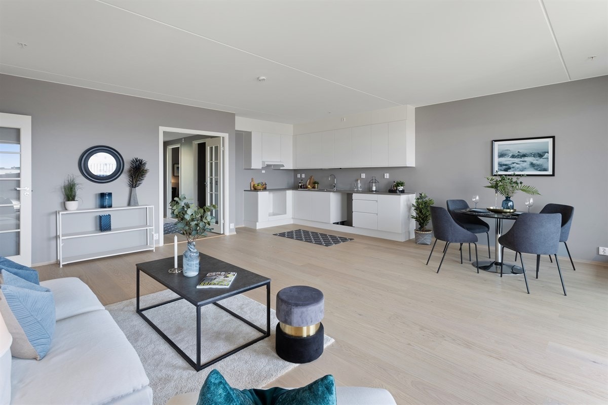 Stue og kjøkken i åpen løsning med utgang til vestvendt takterrasse og balkong. Galleribilde