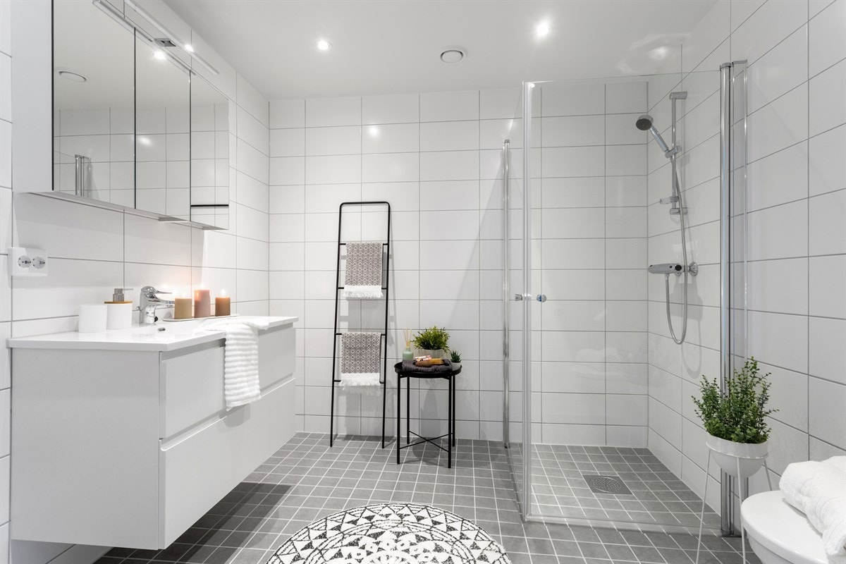 Hovedbadet er av god størrelse med varmekabler i gulv, opplegg for vaskemaskin og tørketrommel, downlights i tak, dusjvegger i glass, servant med underskap og praktisk speilskap. Galleribilde