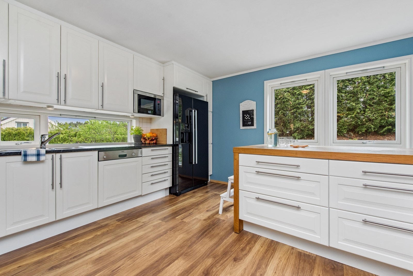 1.etg: Lekkert kjøkken med profilerte fronter med belysning under overskap, fliser på vegg over benkeskap, samt laminat benkeplate. Galleribilde