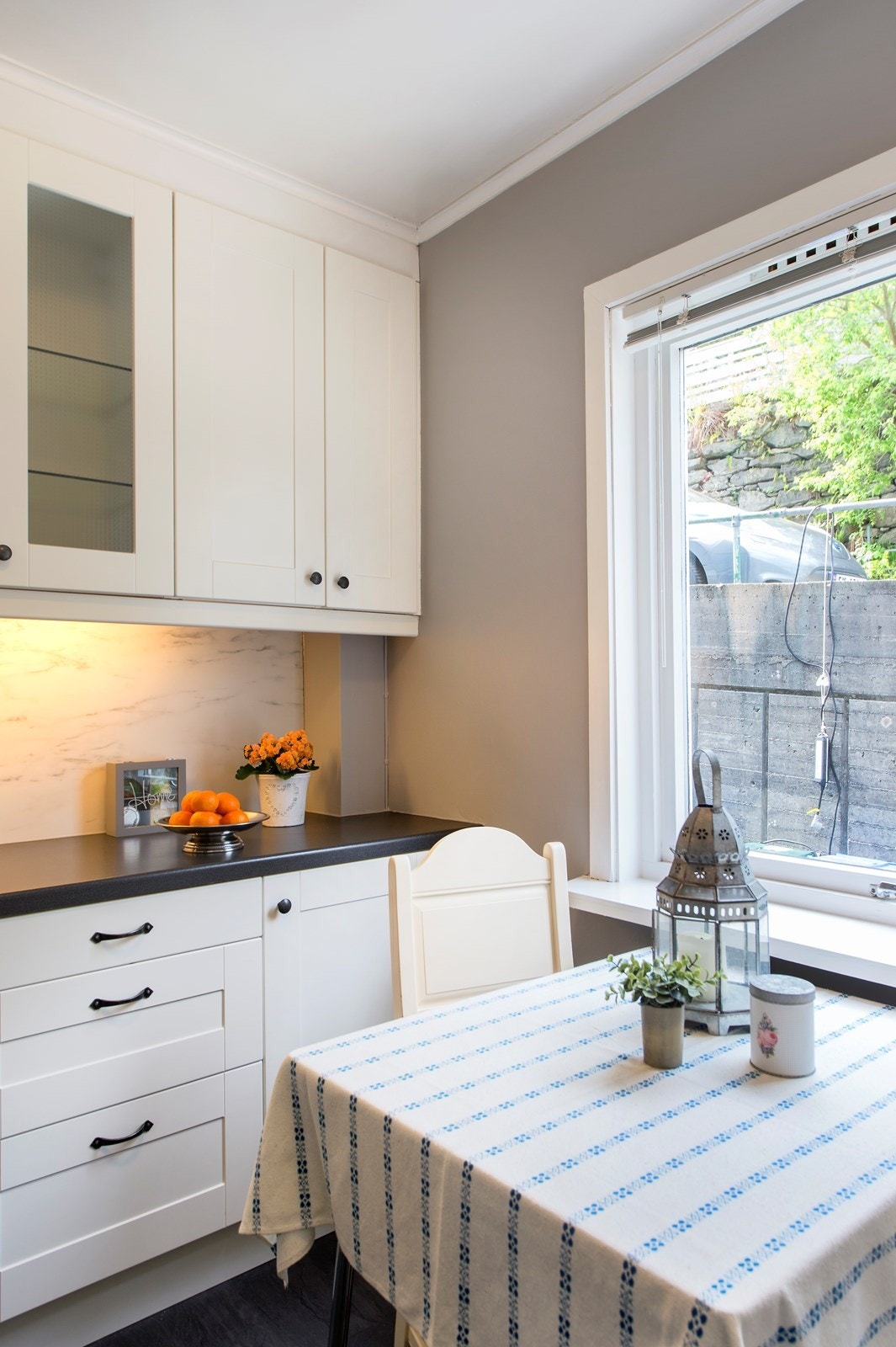 Innredningen har hvite profilerte fronter og stilrene respatexplater i "marmor" mellom benk og overskap. Galleribilde