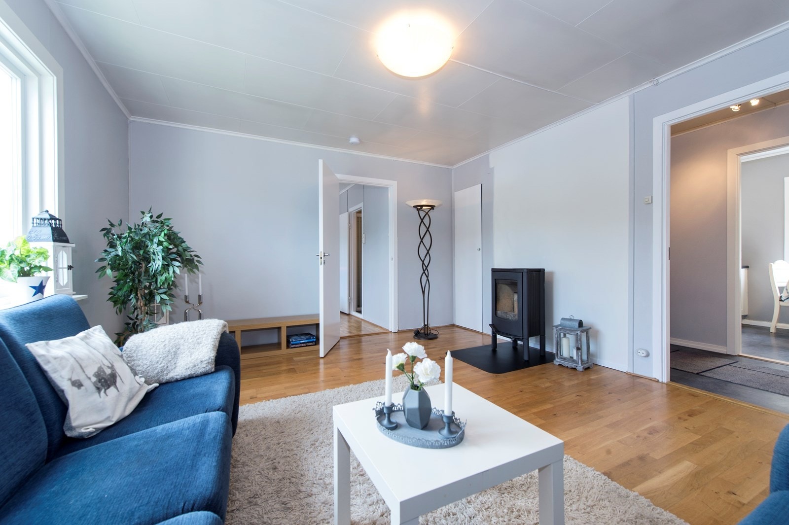 Stuen har lyse og velholdt overflater, med plass til sofa- og sittegruppe. Rommet inneholder vedovn og varmepumpe. Galleribilde