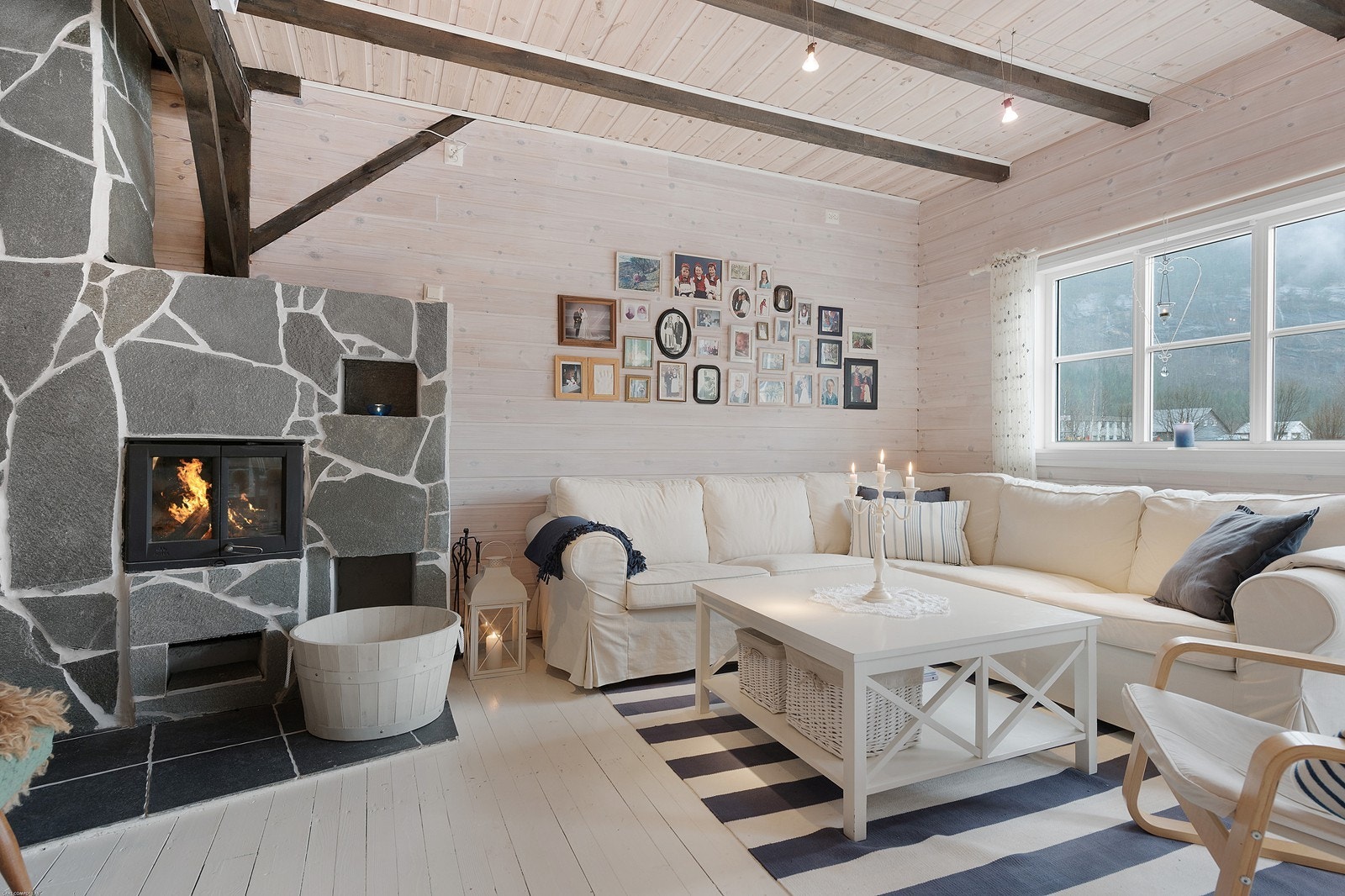 Stue nr.1 ligger i første etasje. Lyse trivelige farger på overflatene og peisovn for kalde vintersdager. Galleribilde