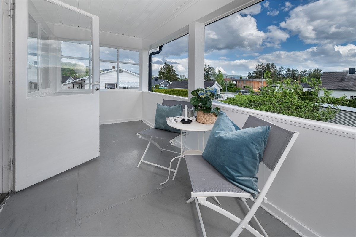 Verandaen er sydvendt og har trapp av metall ned til hagen. Galleribilde