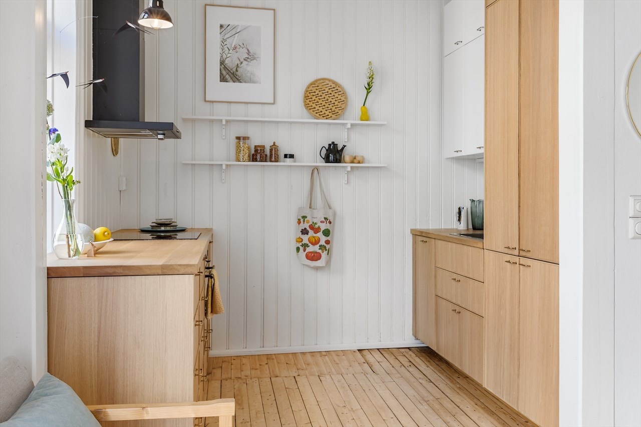 Kjøkkeninnredning med finerte eikefronter, eik benkeplate, ventilator, komfyrvakt og integrerte hvitevarer. Galleribilde